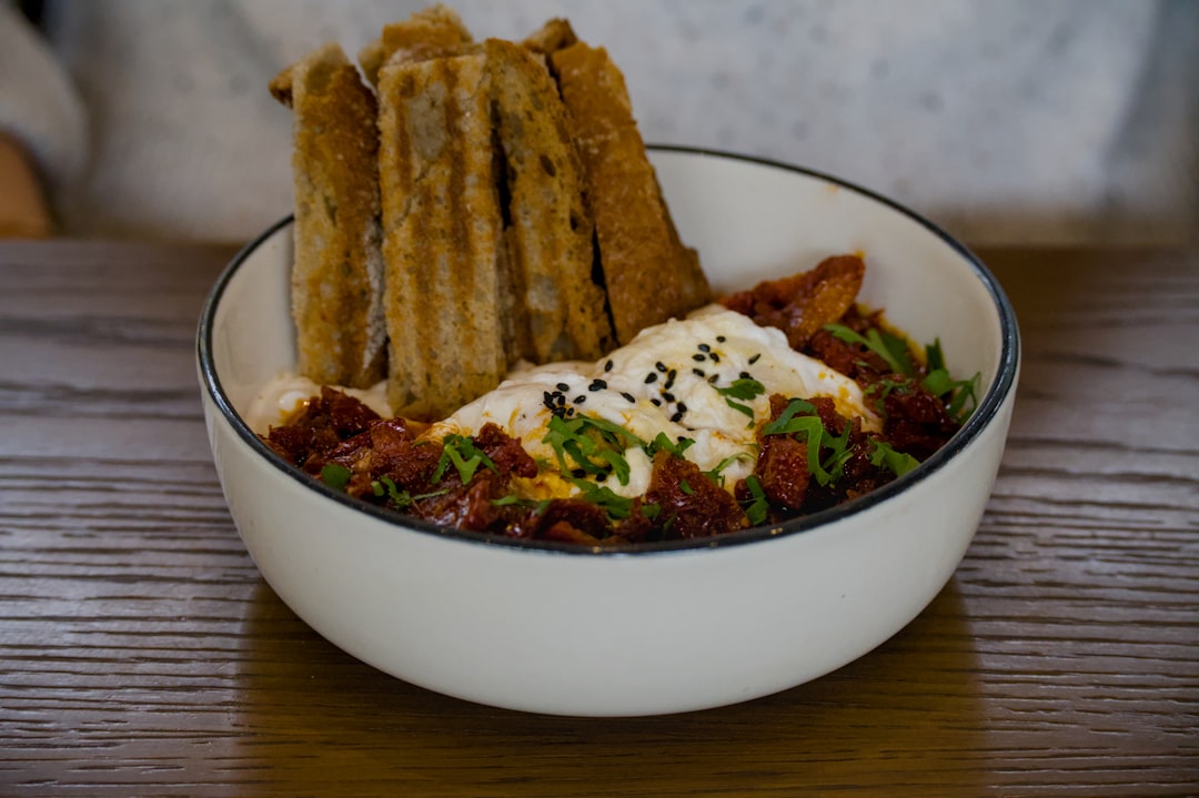Bowl of food with fried breadsticks on top